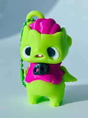 Close-up of zombie bag charm standing with neon green body, big eyes, and open mouth showing tooth