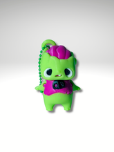3D printed zombie bag charm standing with neon green body, big eyes, and open mouth showing tooth