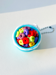 Top-down image of 3D printed cereal clicker with milk splashes and multicolor cereal rings