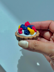 Fruit tart fidget toy keychain held in hand without bite mark, displaying its full design, rounded tart crust, and colorful topping