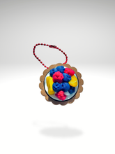 3D printed fruit tart fidget keychain viewed from the top, showing swirled cream topping with berries and peach slices for a realistic dessert look