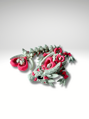 3D printed articulated Heart Dragon in Khaki-Pink posed in a curled position, showing front view of head, body segments, and heart-tail