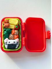 3D printed red bento box clicker opened to show all three internal food-themed clickers: cat-shaped onigiri, karaage, and tamagoyaki