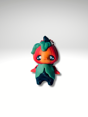 Articulated 3D printed pumpkin pixie charm standing upright with orange head and leaf body