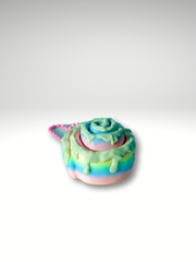 3D printed rainbow pink cinnamon roll fidget toy with frosted swirl design in white background showing the side of cinnamon roll and ball bead chain