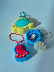 3D printed Sea Friends fidget toy keychains (turtle, seashell, octopus) displayed together, with one open to reveal the internal key switch clicker mechanism