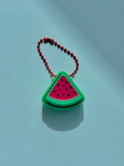 3D printed watermelon slice fidget keychain placed on a table, highlighting the realistic fruit design and compact size