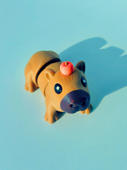 3D printed articulated brown capybara figure with a small pumpkin on its head