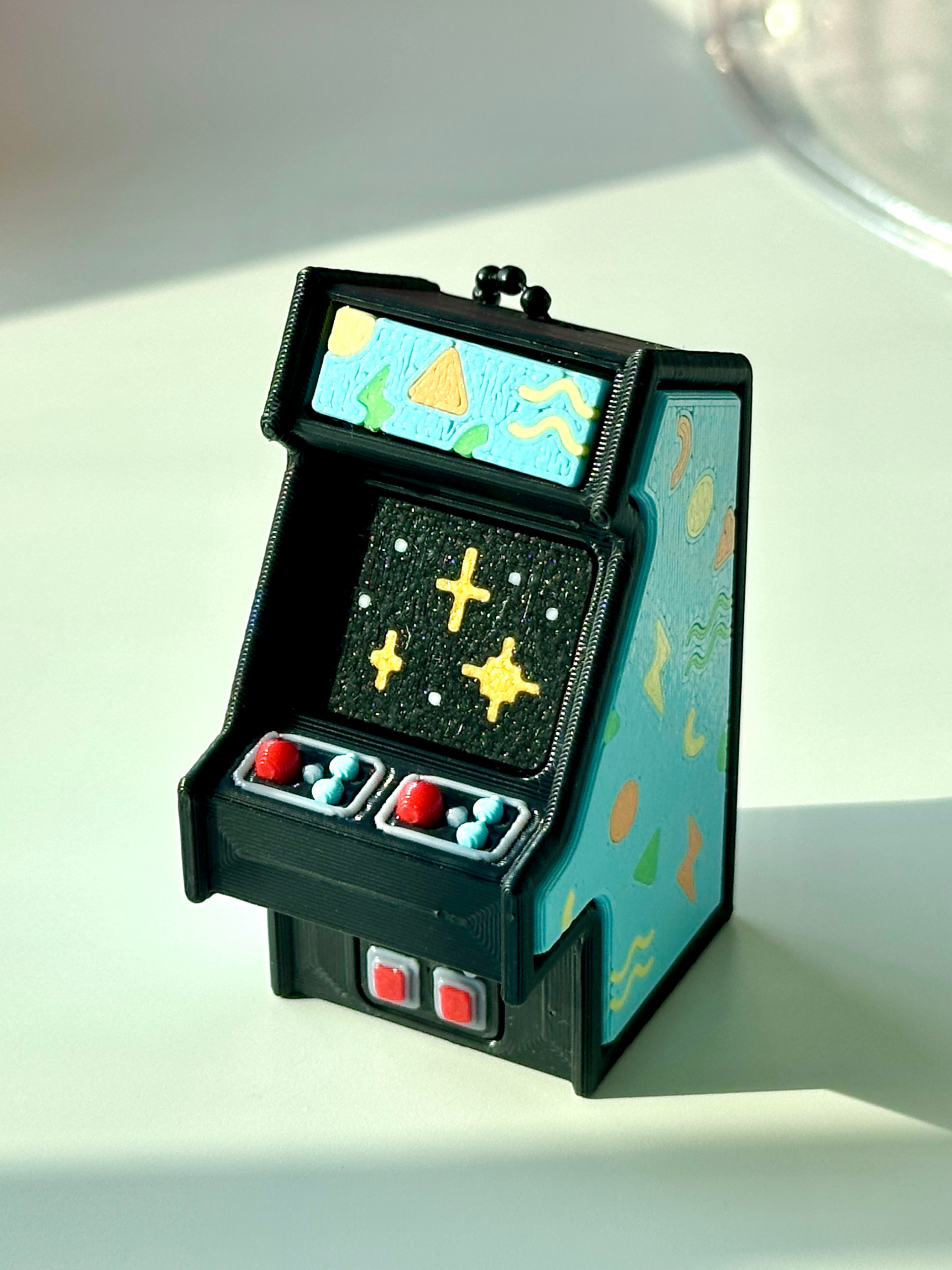 Geometric Retro Arcade Clicky Pal – cream 3D printed mini arcade cabinet clicker keychain with gold line-art and a pixel-trophy screen | Dubai 3D Printing
