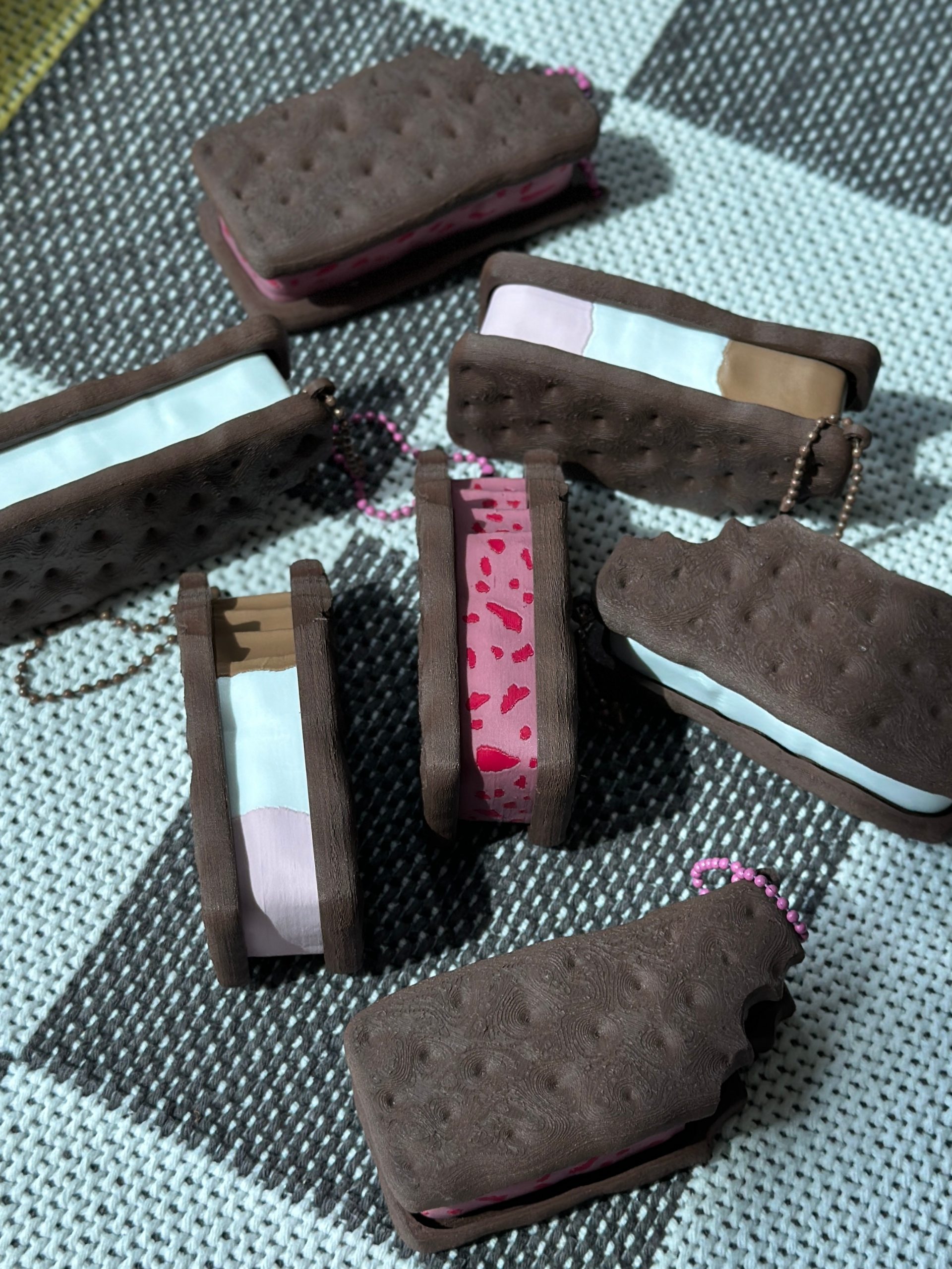 3D printed ice cream sandwich fidget toy keychains in vanilla, strawberry, and Neapolitan flavors arranged in a flat lay display