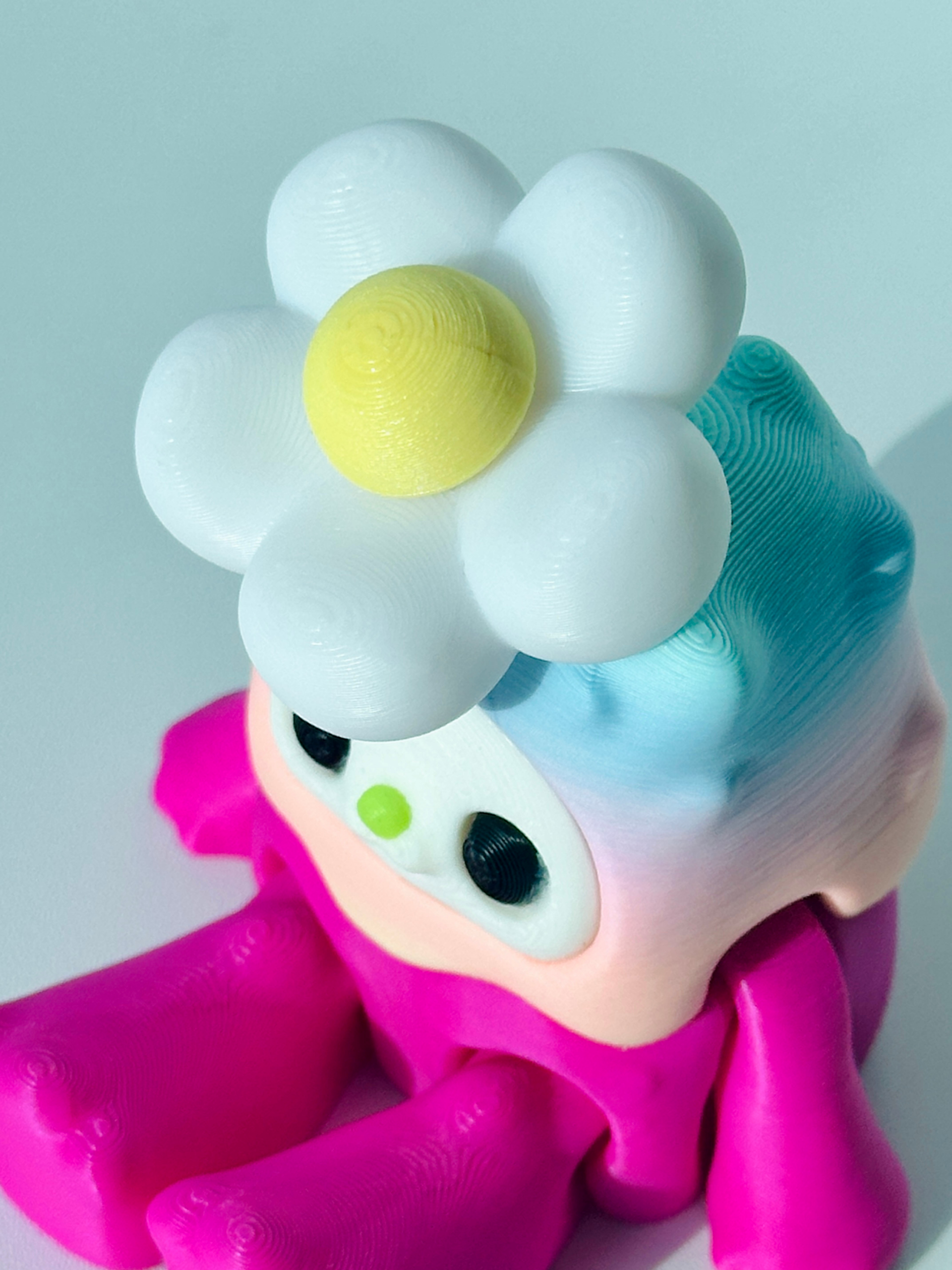 Woobu Daisy Spinner close-up view of the head and flower fidget spinner placed on a desk